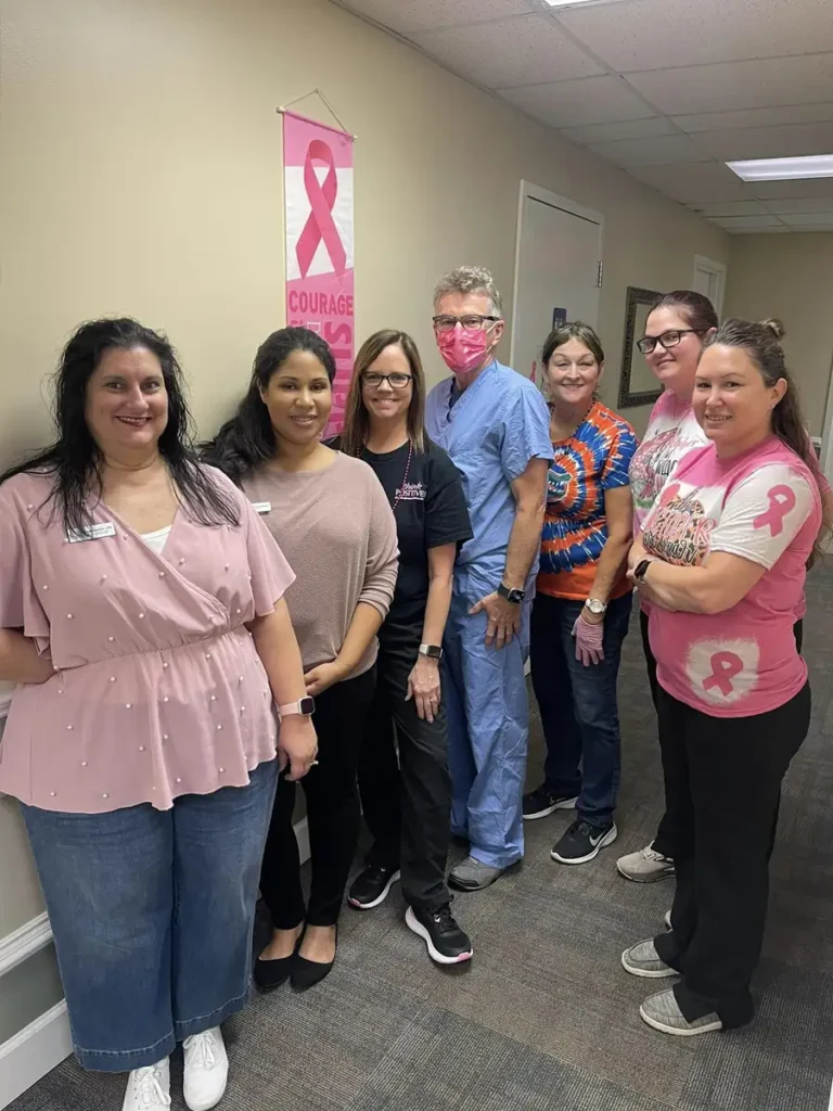 Team members showing support for Breast Cancer Awareness Month