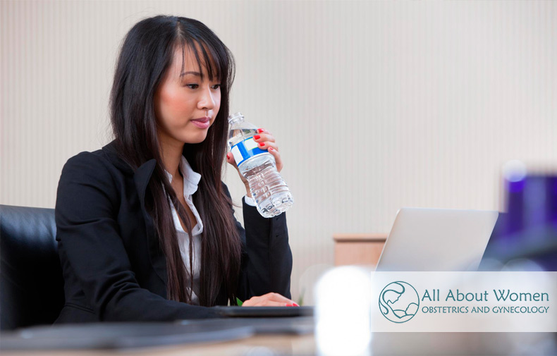 woman drinking water at her desk